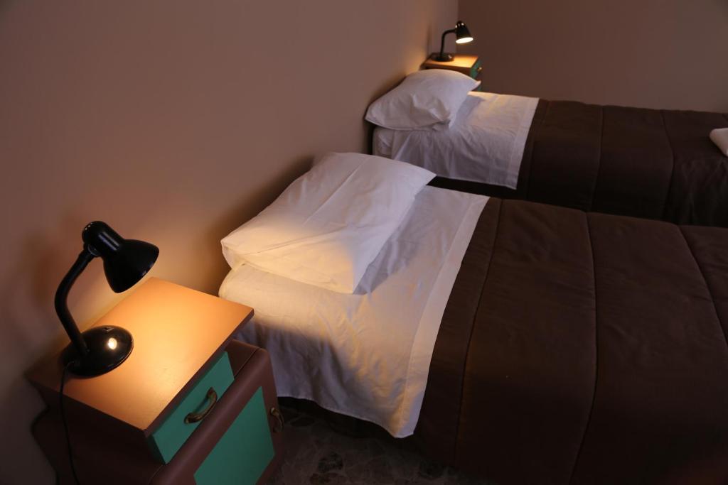 1 dormitorio con 2 camas y una lámpara en una mesa en Casa Andrea, en Rávena