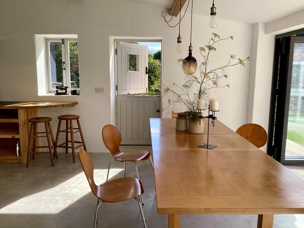 a dining room with a wooden table and chairs at Home Farm - theundergroundstream in Churchstow