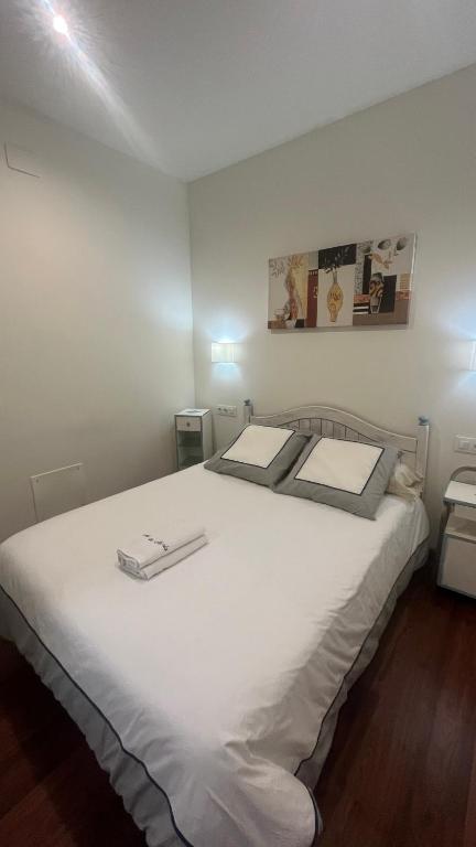 sypialnia z dużym białym łóżkiem z białą pościelą w obiekcie A de Maria - Tres Marias Apartments w mieście Redondela