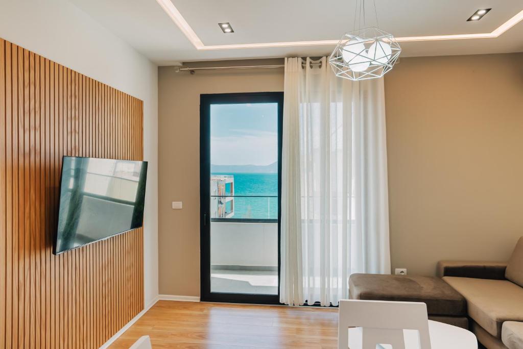 een woonkamer met een bank en een raam bij JD Luxury Apartments in Vlorë