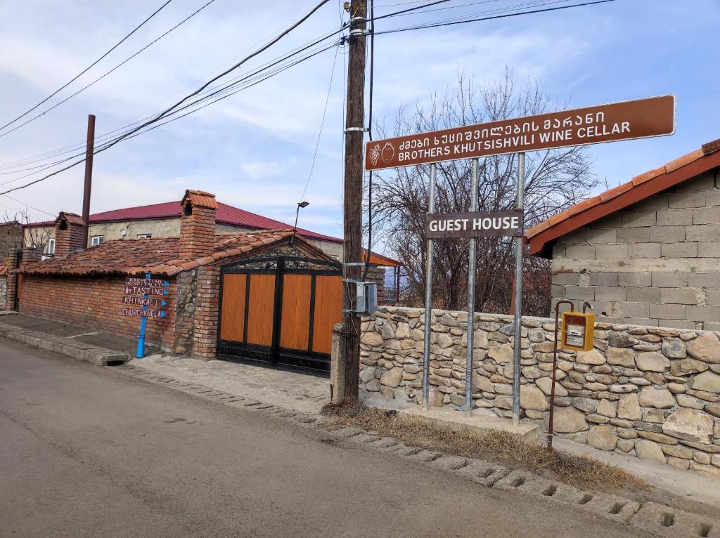 un panneau de rue devant un bâtiment en briques dans l'établissement Brothers khutsishvili wine cellar, à Kisiskhevi