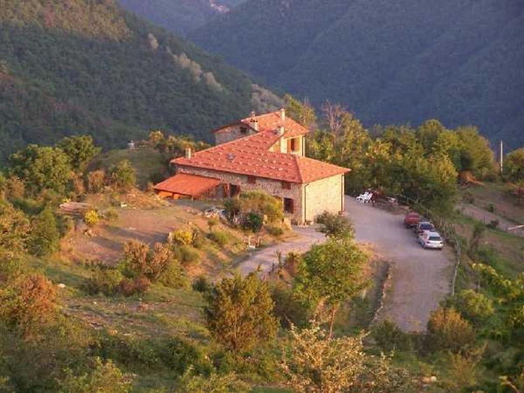 a house on a hill with cars parked in front of it at Casa della Barcareccia in Calice al Cornoviglio