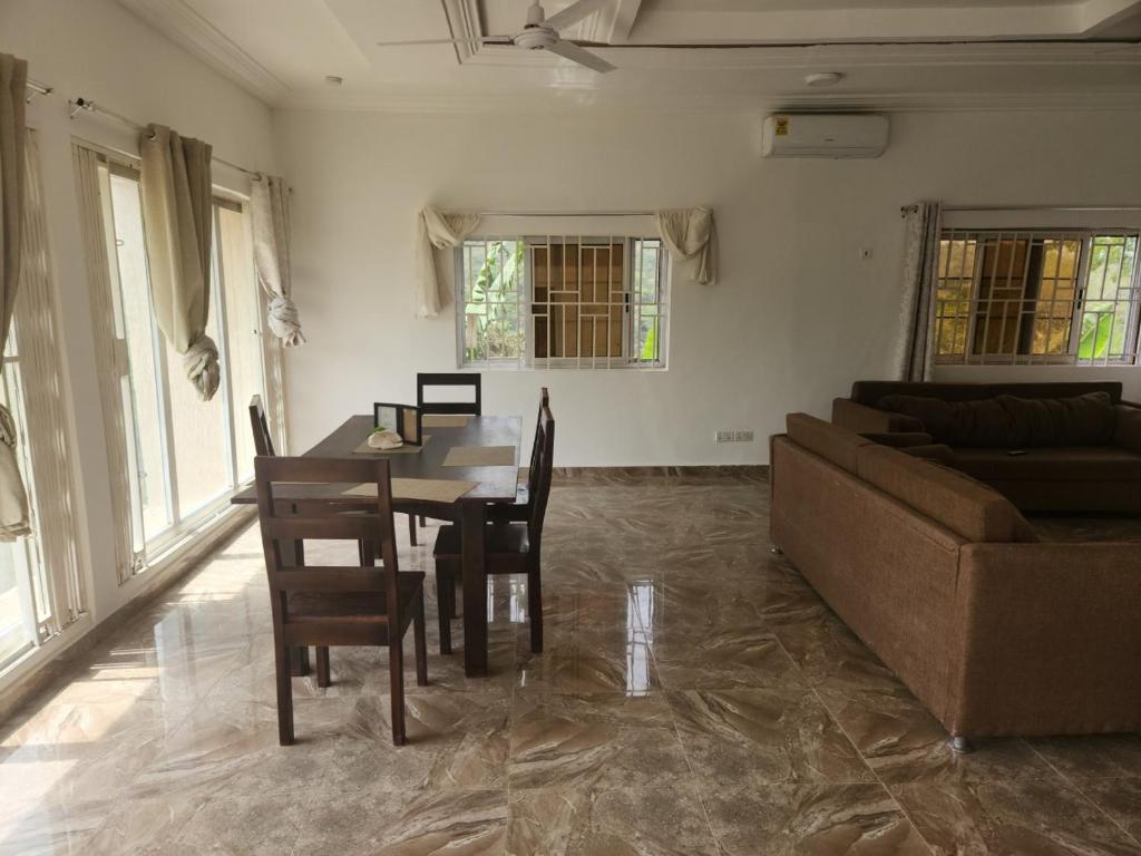 un soggiorno con tavolo e divano di 3 Bedroom Serene home In Kwahu 