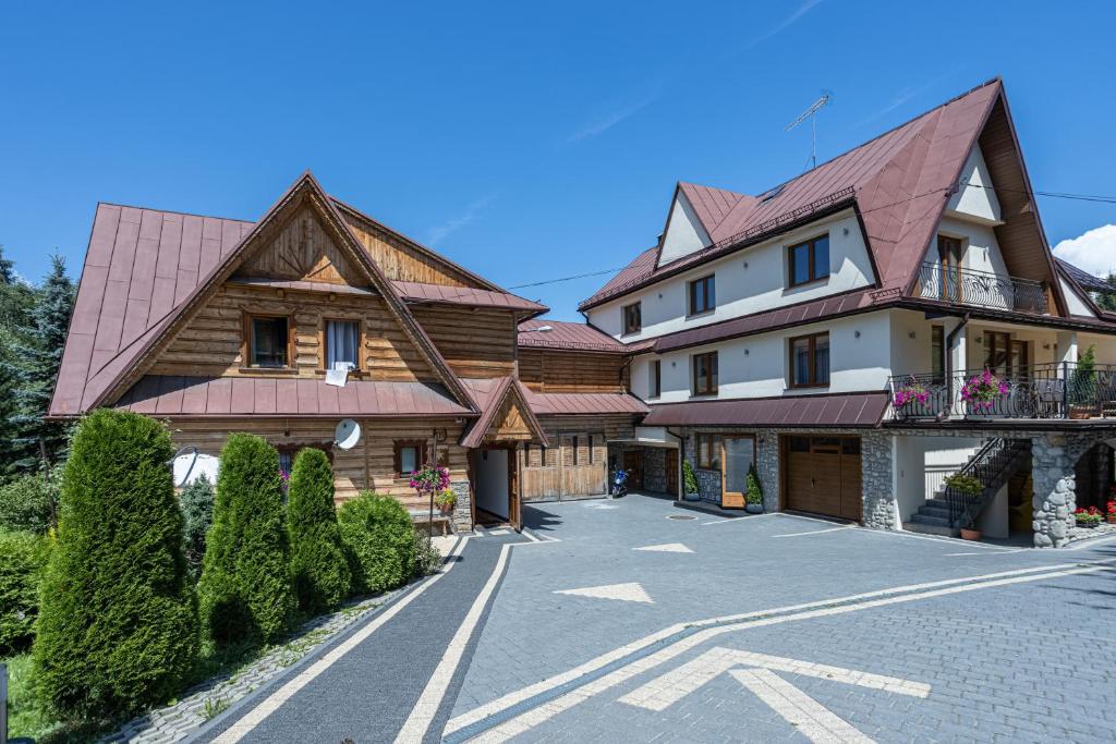 a large house with a tiled roof on a street at Szarotka in Bukowina Tatrzańska