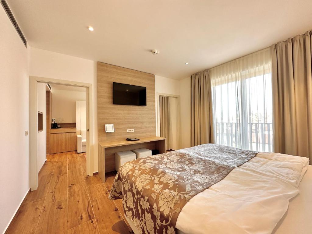 a hotel room with a bed and a desk and a television at Boutique Hotel Grahor in Sežana