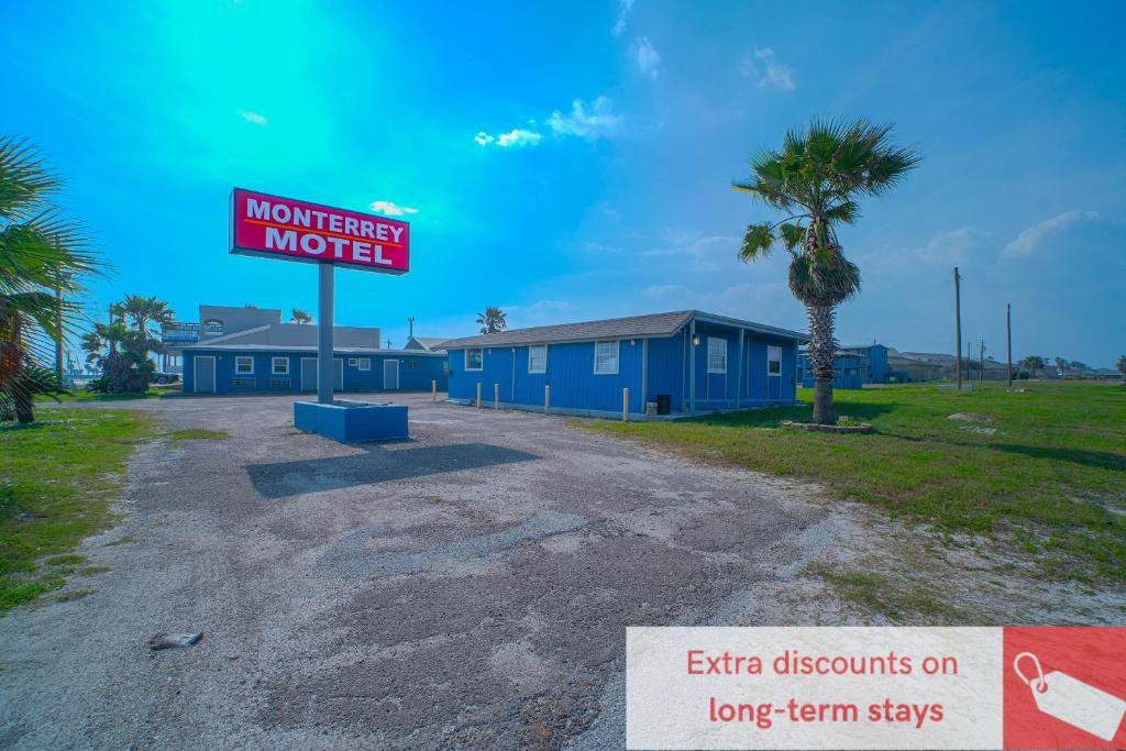 a motel sign sitting in the middle of a road at Monterrey Motel Padre Island, Corpus Christi BY OYO in Corpus Christi
