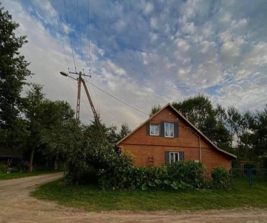 にあるOzierański Eden "Pod rzeźbami"の風車のある道路脇の家