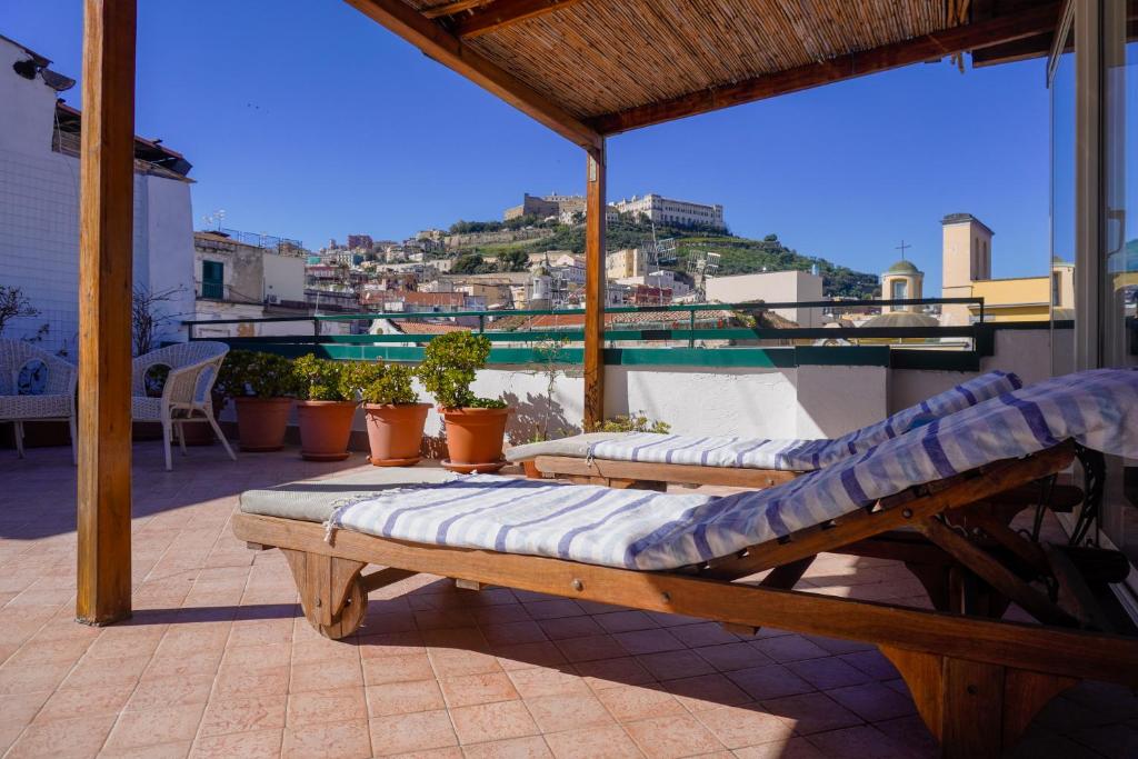 two chaise lounges on the roof of a house at Case Così Apartments - Napoli in Naples