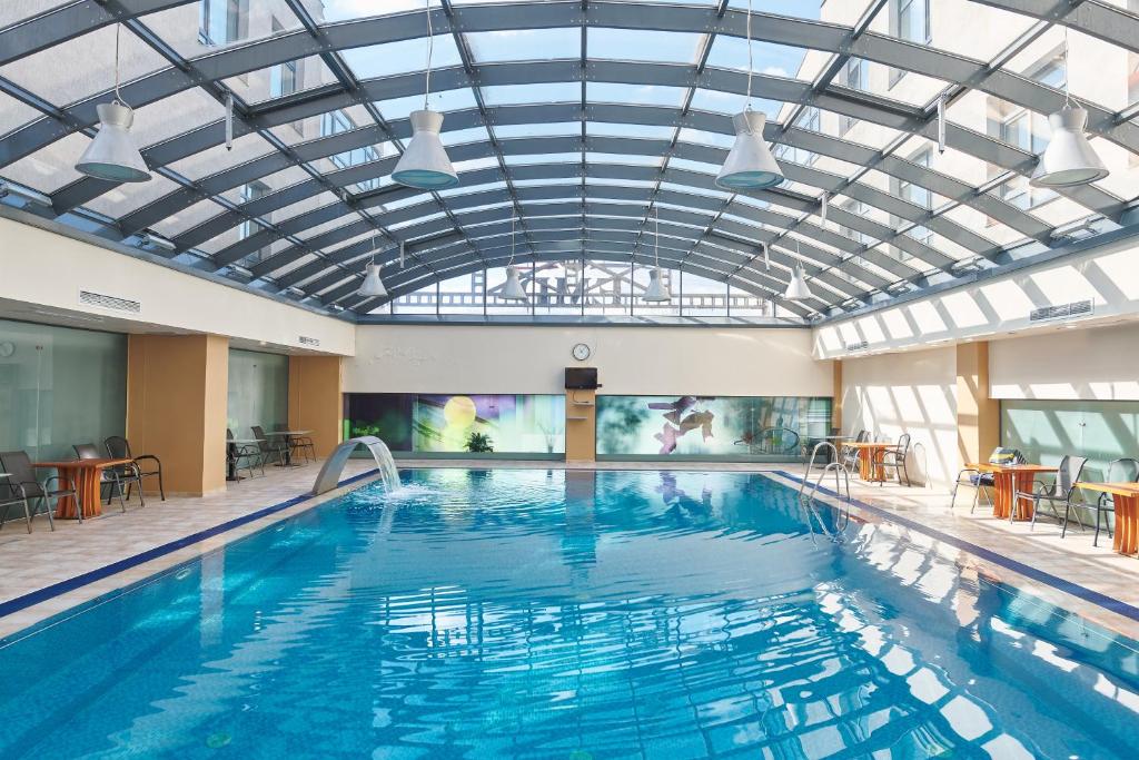 a large swimming pool with a glass ceiling at Hotel EMD in Bacău