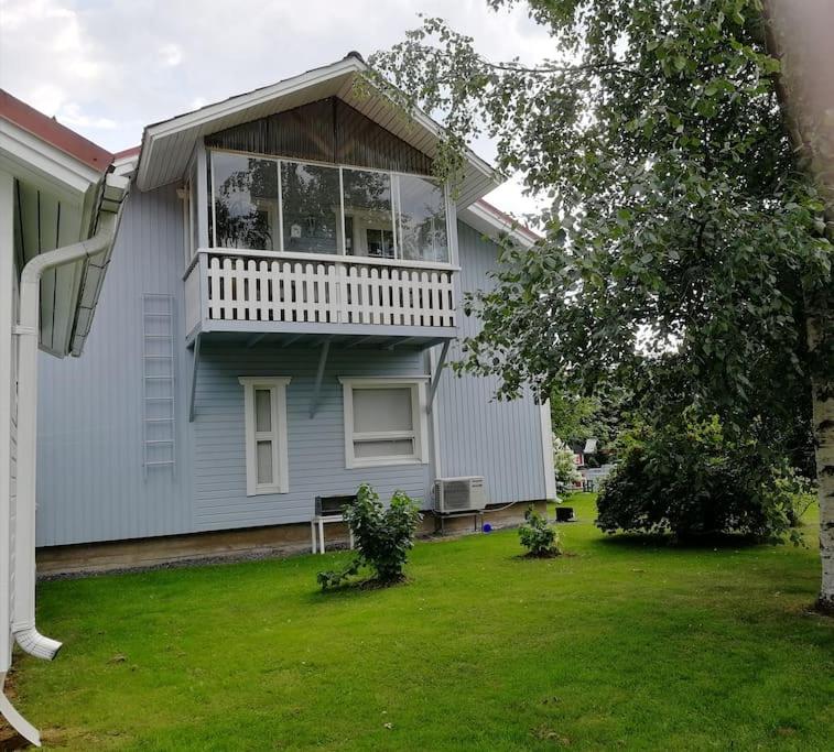a house with a balcony on top of a yard at Tupaniemi, kodikas ja tilava asunto 2-4 vieraalle in Pori