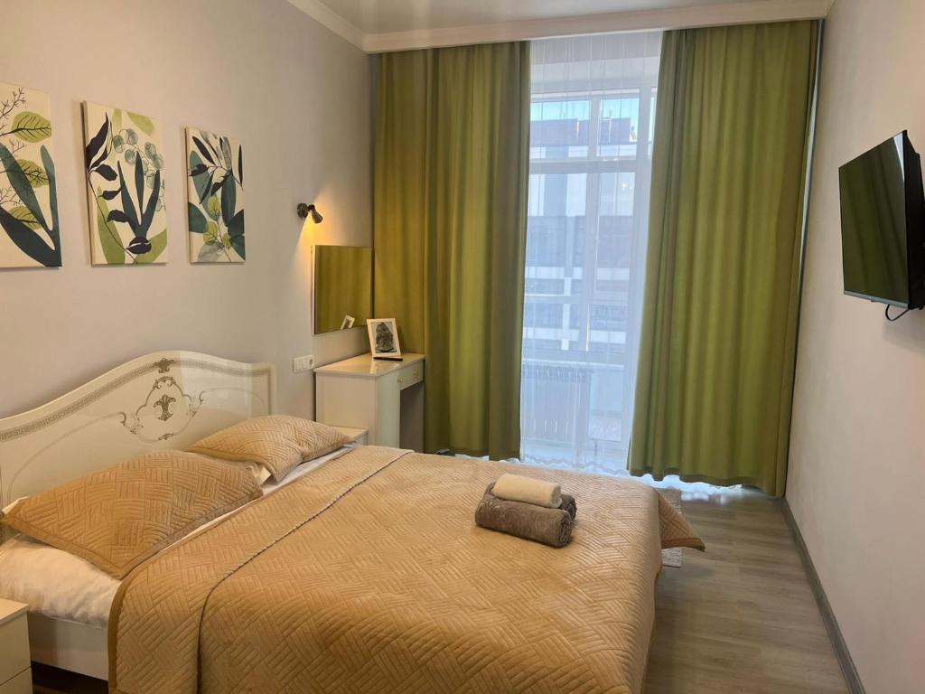 a bedroom with a bed and a large window at ЖК Champion in Astana