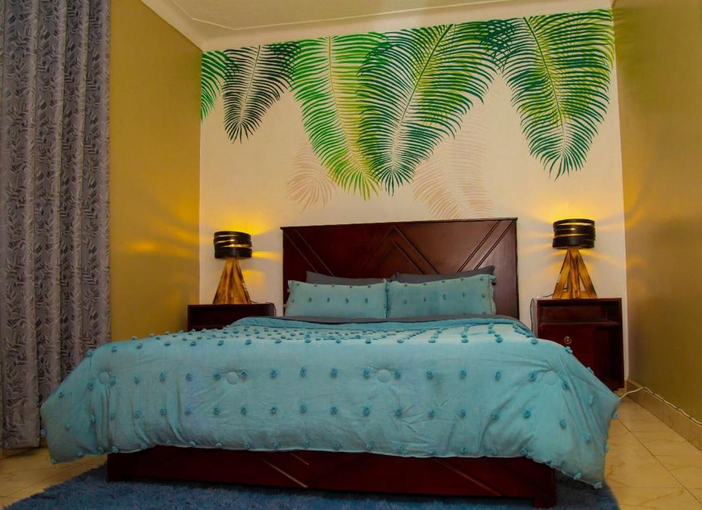een slaapkamer met een groot bed met een groen bladschilderij aan de muur bij Modern Furnished Rooms with Netflix, Kitchen, Living room , Laundry DStv and Free WiFi in Kampala