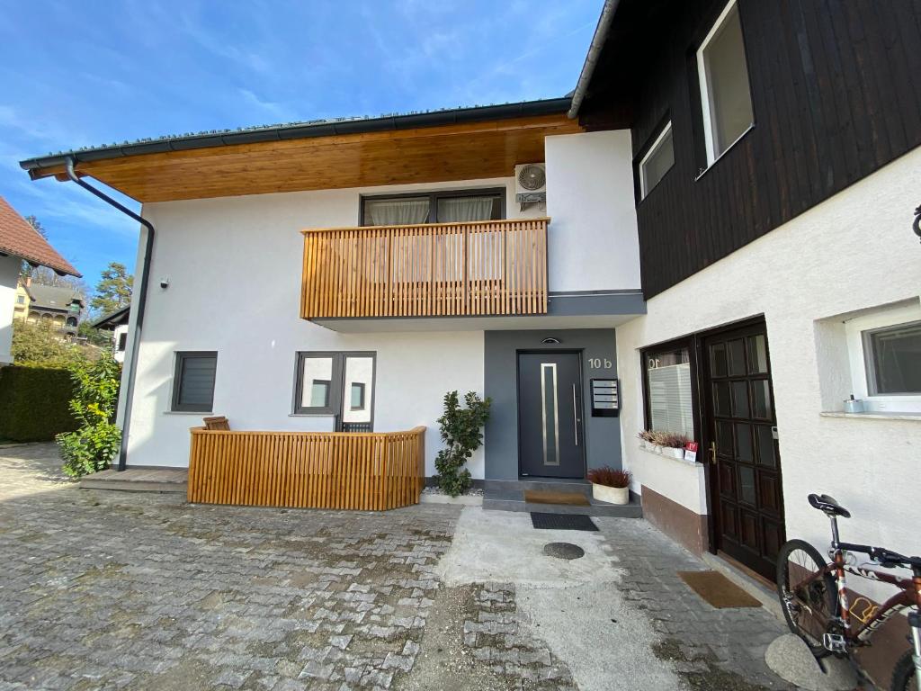 uma casa branca com uma varanda e um alpendre em Bled Lake Apartment House em Bled