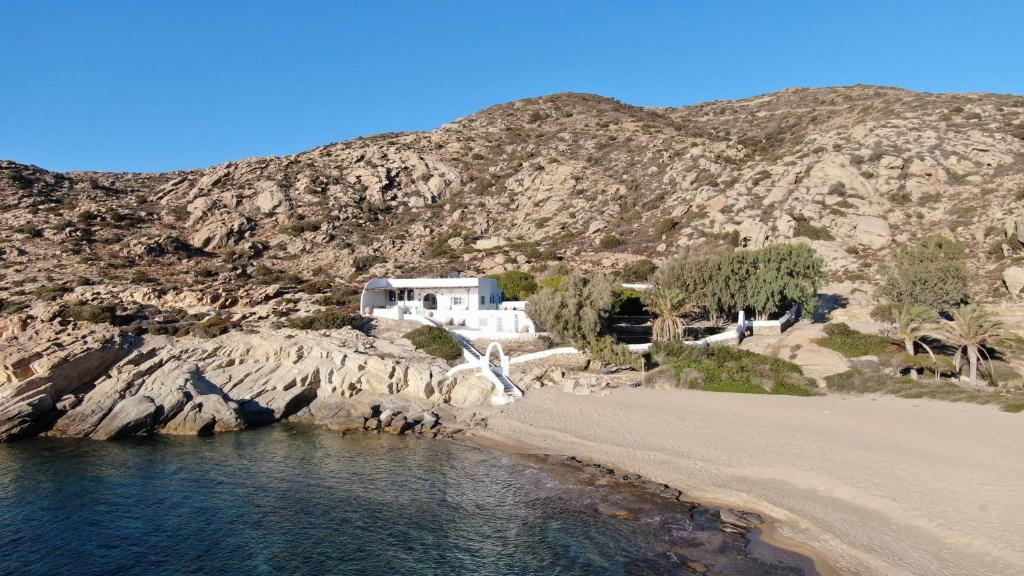 a house on a beach next to the water at IosVilla at Sapounohoma in Mylopotas