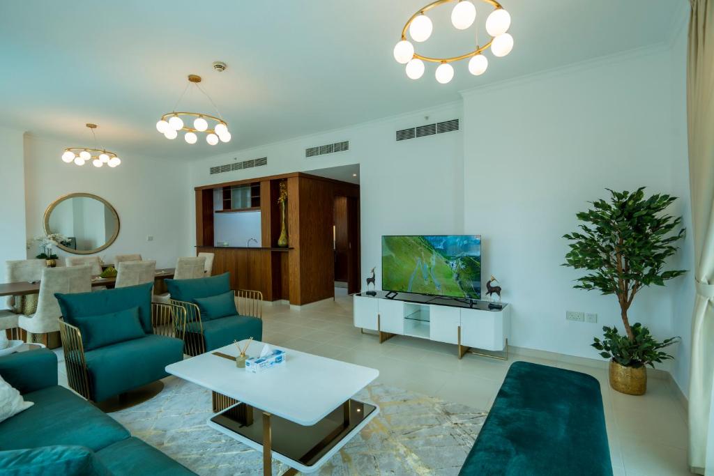 a living room with a blue couch and a tv at INA Homes-Residences Tower 7 Full Burj Khalifa & Fountain Views in Dubai