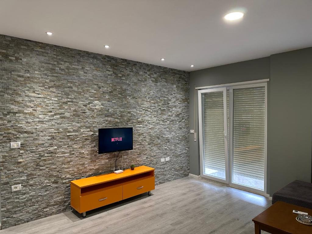 a living room with a tv on a brick wall at Panorama Apartments in Tirana