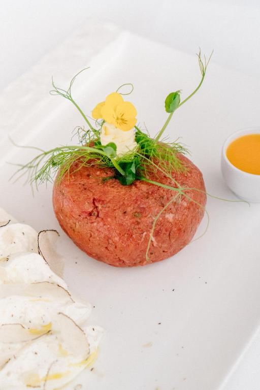 a carrot with flowers on it on a white plate at Hotel Grahor Depandance in Sežana