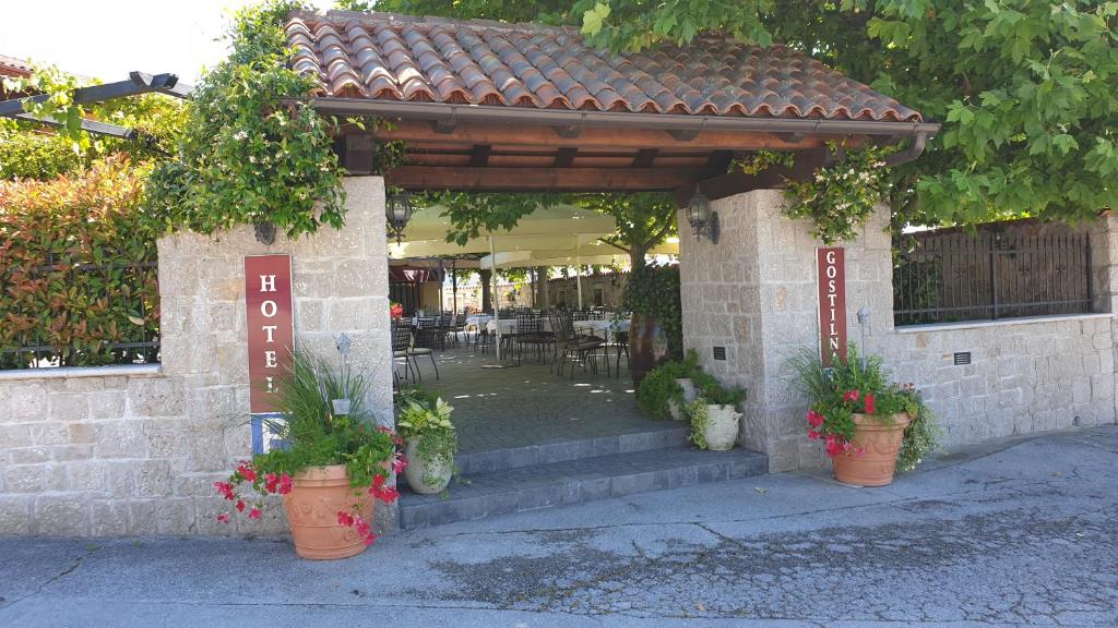 a building with a porch with potted plants at Hotel Grahor Depandance in Sežana