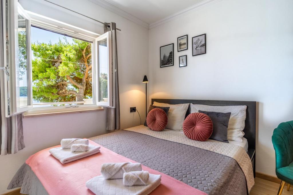 a bedroom with a large bed with a window at Apartments Klara in Molunat