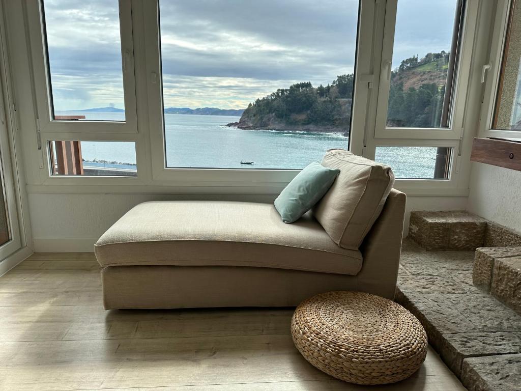 a living room with a couch and two large windows at BURUMENDI 4 in Mutriku