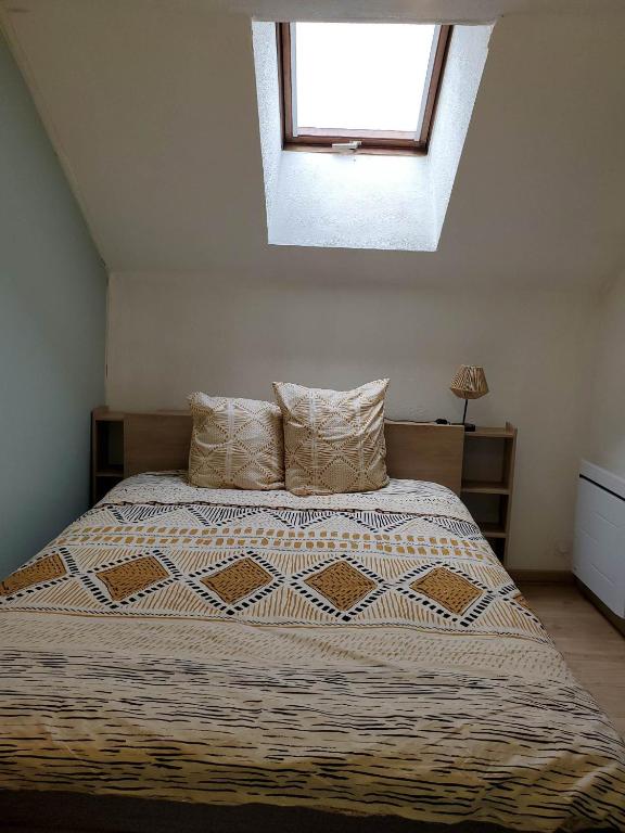 a bedroom with a large bed with a window at Studio grand lit 160 tout équipé wifi in Le Creusot