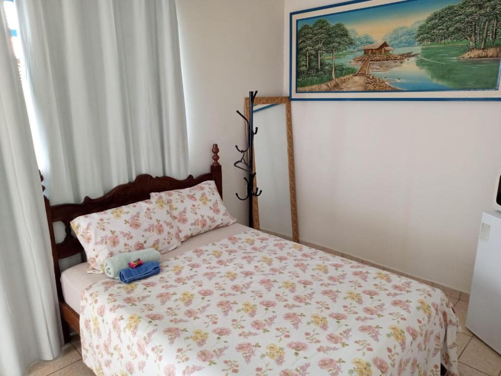 a bedroom with a bed with a pillow and a painting at Benvivere - Indaiatuba - Seu descanso é aqui! in Indaiatuba