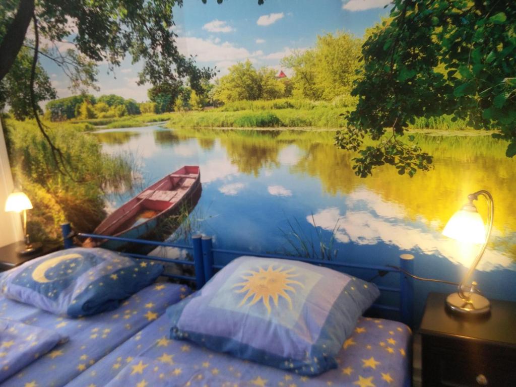 um quarto com uma cama e um barco num rio em Ferienwohnung Zur Weißen Taube em Dobbertin