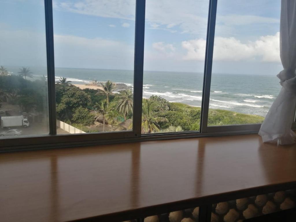 a window with a view of the ocean at Beach Road Holiday Apartment in Amanzimtoti