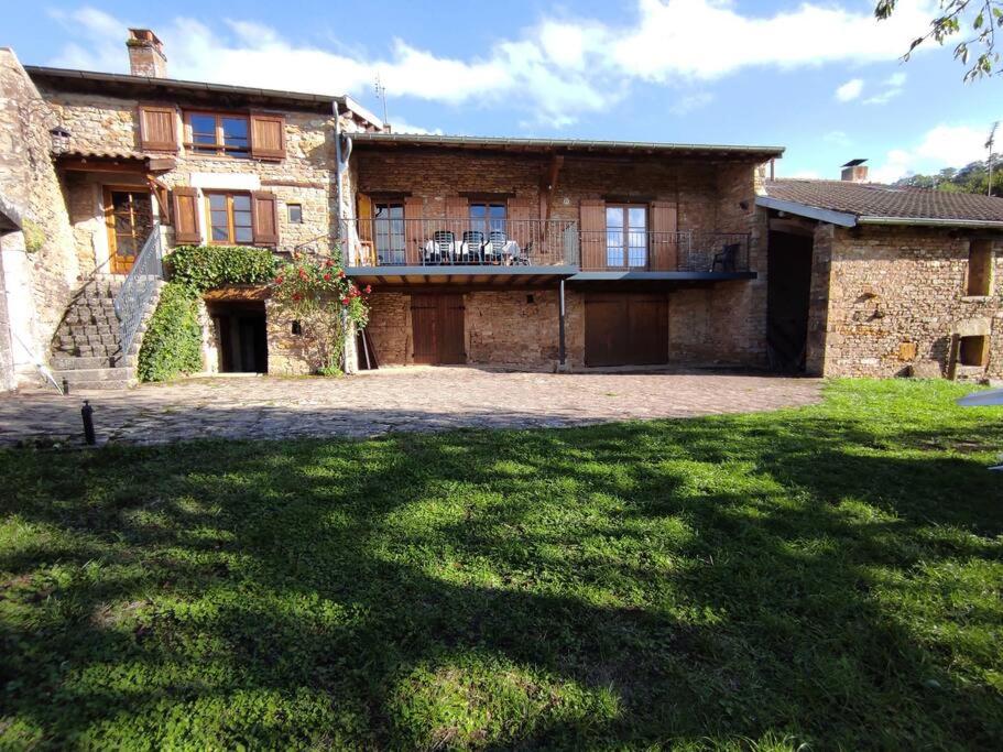 duży ceglany dom z ogródkiem przed nim w obiekcie Maison de famille en Bourgogne proche de Cluny w mieście Saint-Point
