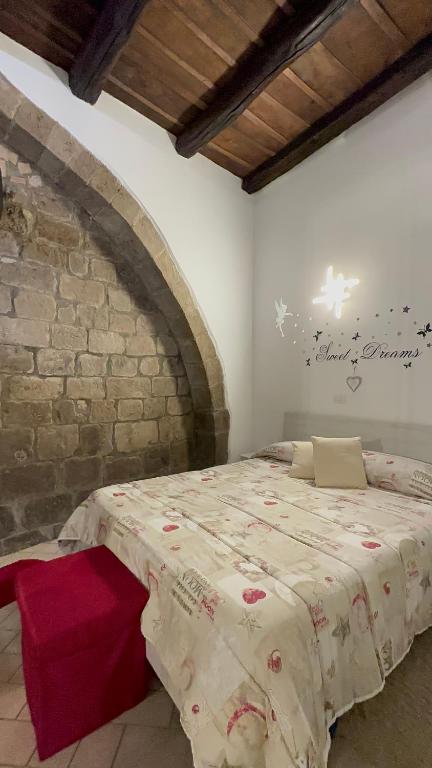 1 dormitorio con 1 cama en una pared de ladrillo en Casa medievale Il Rifugio di Olimpia, en Viterbo