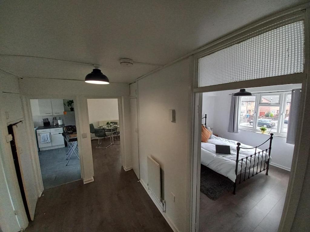 una camera da letto con un letto e un soggiorno con un tavolo di Derby City Apartment with free parking a Derby