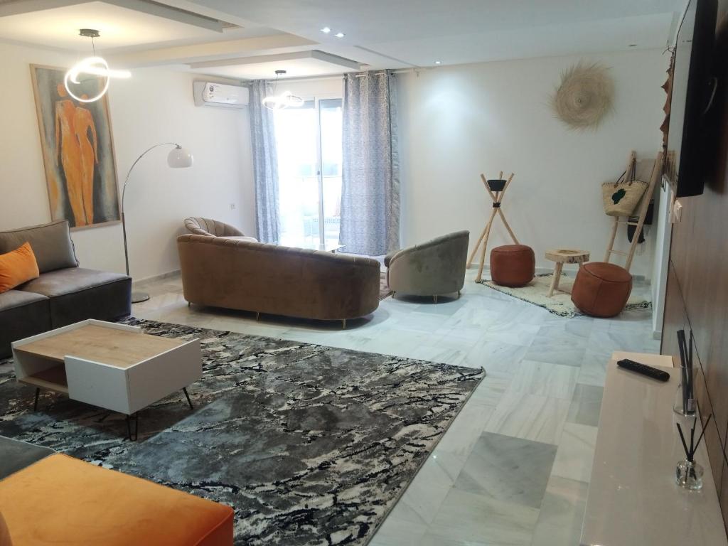 Nouvel appartement climatisé في فاس: غرفة معيشة مع أريكة وطاولة