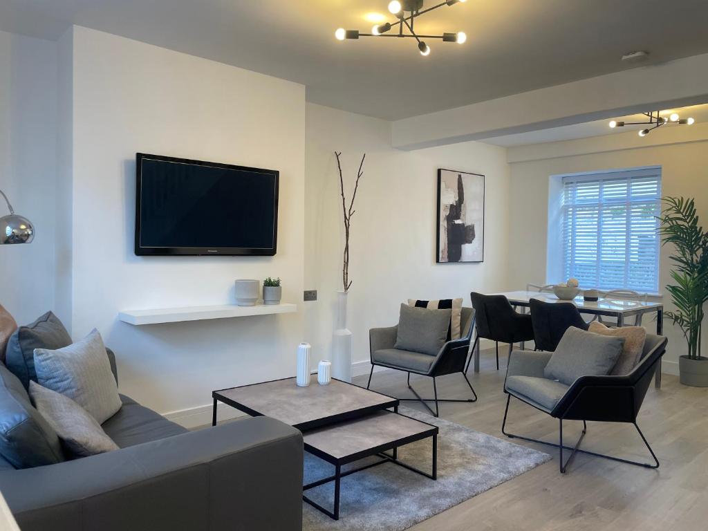 a living room with a couch and chairs and a table at Lux Cottage Conwy in Conwy