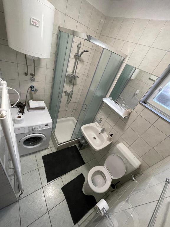 a bathroom with a toilet and a sink and a shower at Apartman ANA in Vrlika