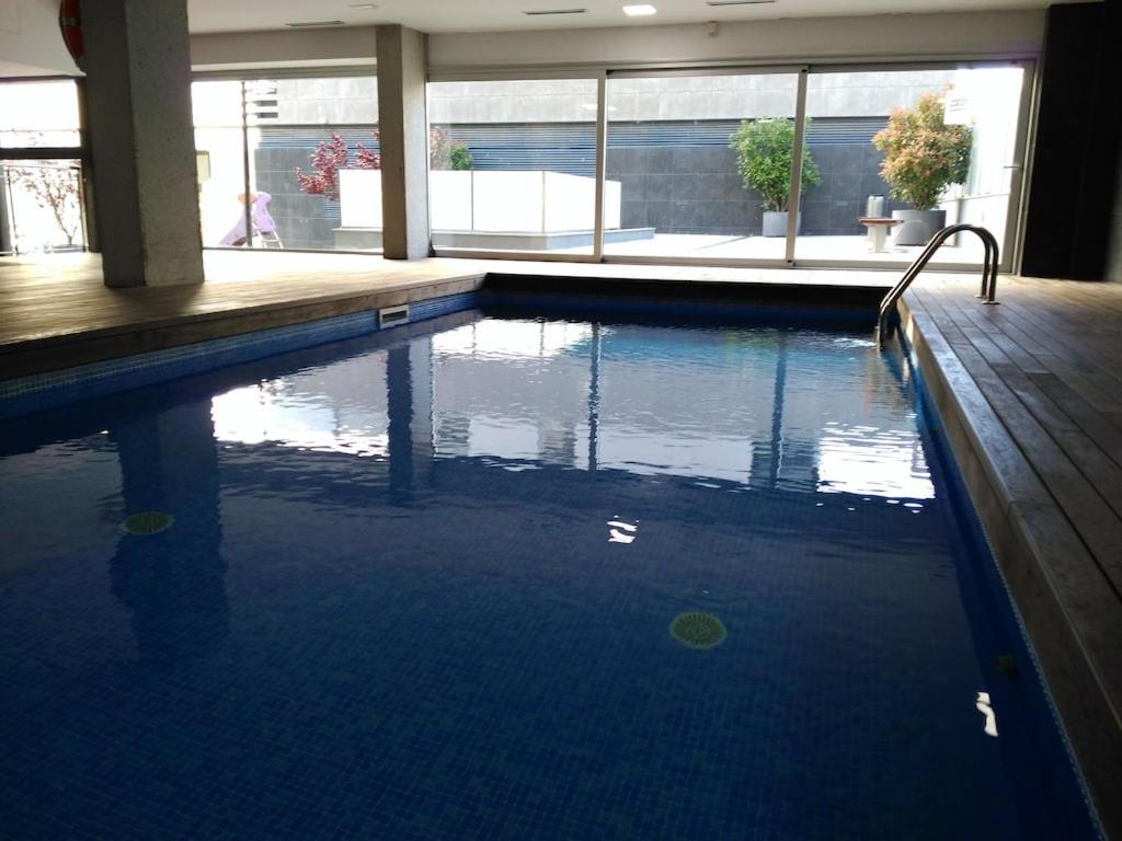 una grande piscina con acqua blu in un edificio di LUXURY FLAT, 3 BEDROOMS, 2 BATHROOMS AND SWIMMING POOL NEXT TO THE BEACH!! a Barcellona