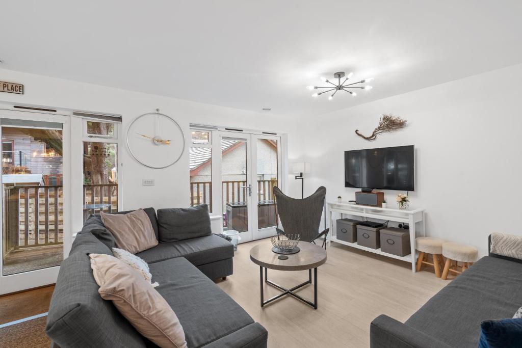a living room with a couch and a tv at Tincroft Cottage - high end, luxury living near the beach in Truro