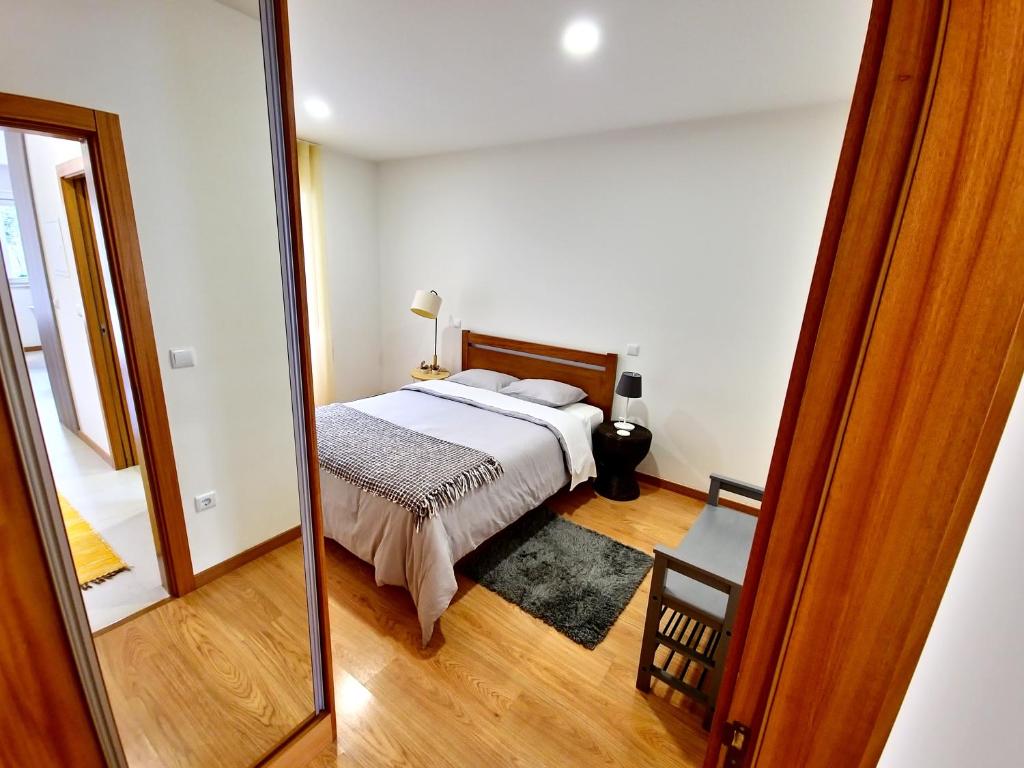 1 dormitorio con cama y espejo en Casa do Rio en Ponte da Barca