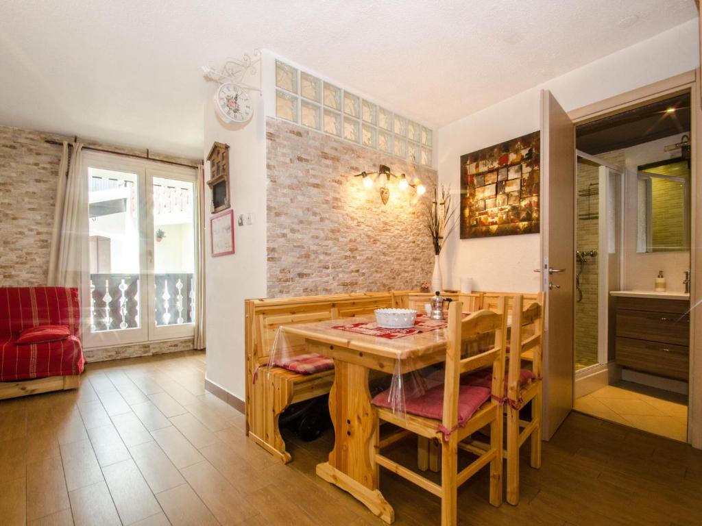 une salle à manger avec une table et des chaises en bois dans l'établissement Studio cosy à Chamonix Sud, proche centre, balcon, 4 pers, parking, WiFi - FR-1-343-235, à Chamonix-Mont-Blanc