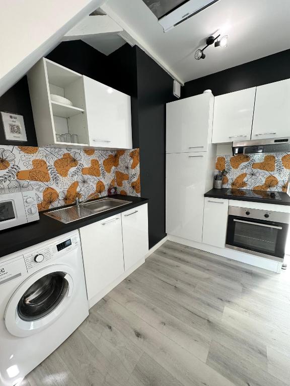 a kitchen with a washing machine and a microwave at L&#39;ENSOLEILLÉ - Classé 2 étoiles - Nay centre - Appartement in Nay