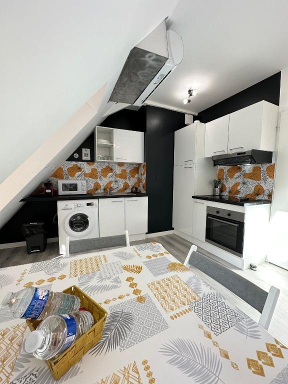 a kitchen with white cabinets and a table with a tray at L&#39;ENSOLEILLÉ - Classé 2 étoiles - Nay centre - Appartement in Nay