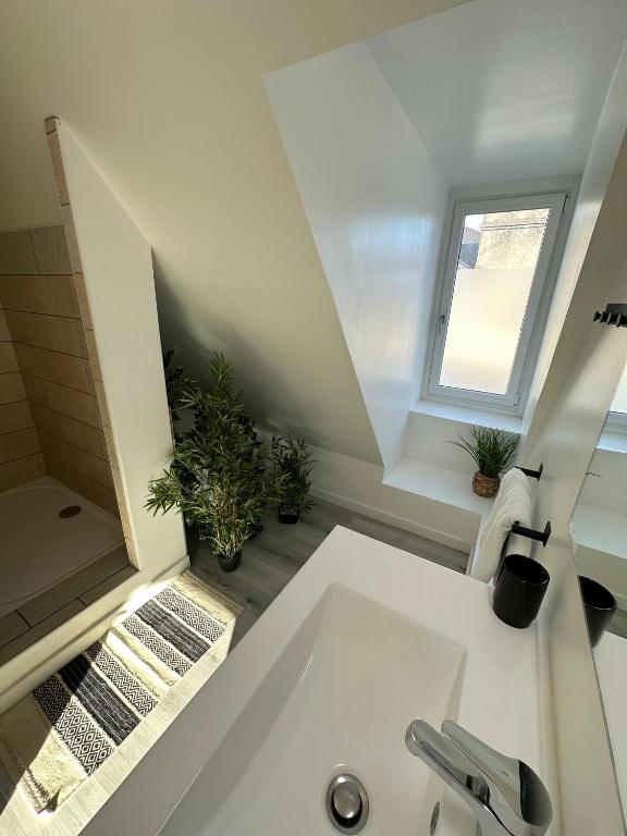 a white bathroom with a sink and a window at L&#39;ENSOLEILLÉ - Classé 2 étoiles - Nay centre - Appartement in Nay