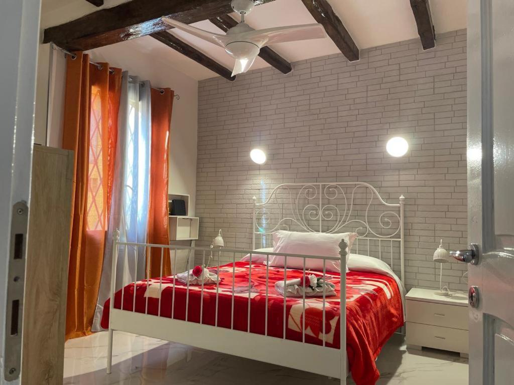 a bedroom with a red bed and a brick wall at CORTICELLA 1 in Bologna