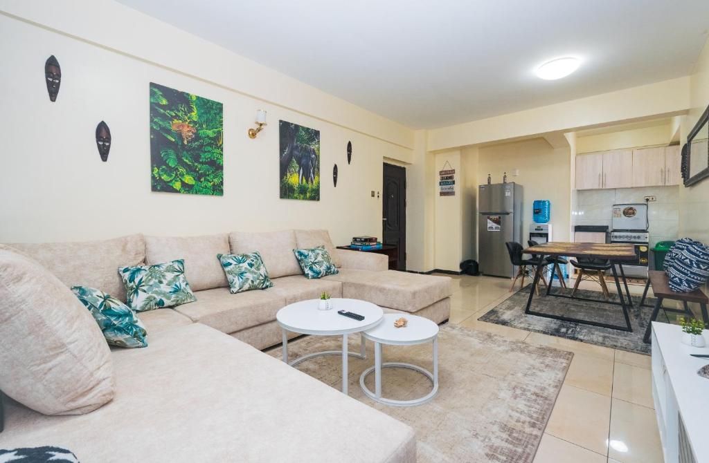 a living room with a couch and a table at Tropical themed 3BR and DSQ Apartment in Nairobi