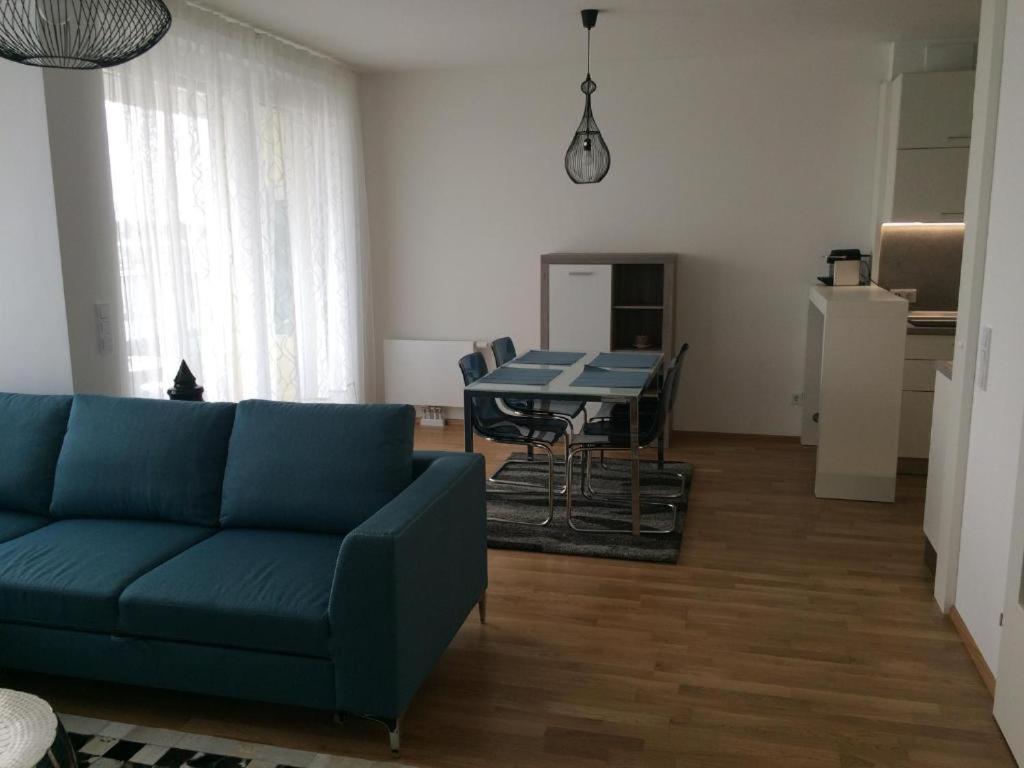 uma sala de estar com um sofá azul e uma mesa em Vienna Belvedere und Hauptbahnhof Apartment em Viena
