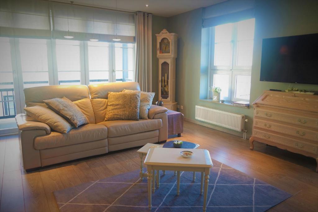 ein Wohnzimmer mit einem Sofa und einem Tisch in der Unterkunft Caramia, Duinhof 5-1-14, Romantic apartment by the sea in Cadzand-Bad
