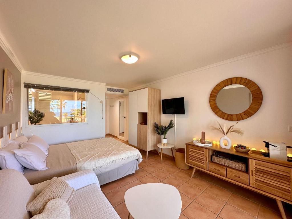 - une chambre avec un lit, un canapé et un miroir dans l'établissement Curaçao 13 studio vue mer proche plage dans Complexe type Village Vacances, à Sainte-Luce