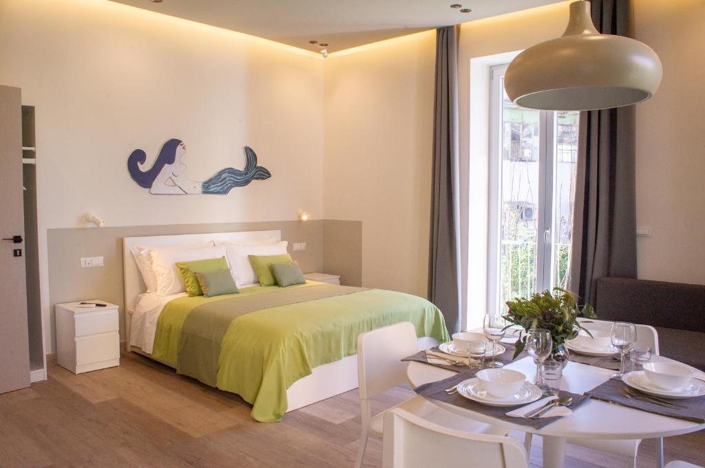 a bedroom with a bed and a table and a dining room at Sirena Partenope e San Gennaro HOME - Rione Sanità - Centro Storico Napoli in Naples