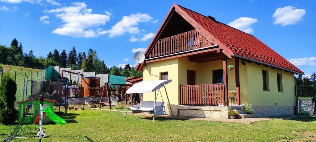 ein kleines Haus mit einem Spielplatz mit Rutsche in der Unterkunft Chata Horbek Wellness in Vyšné Ružbachy
