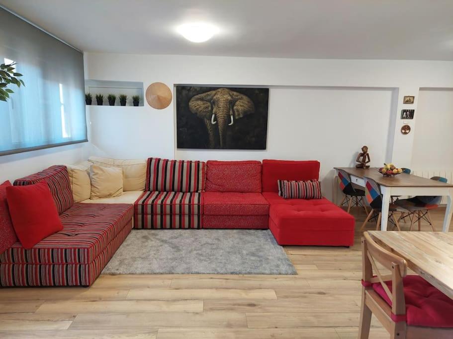 un soggiorno con divano rosso e tavolo di Family apartment Andrea a Alaquas
