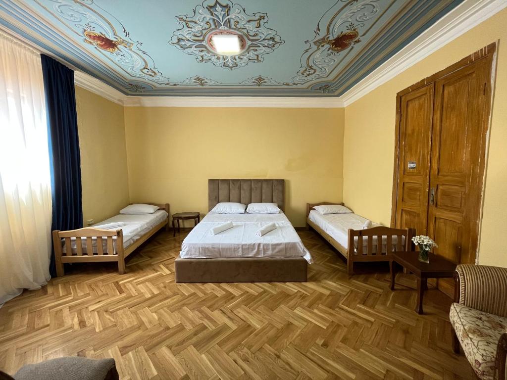 Tiflisi Hostel في تبليسي: غرفة نوم بسريرين وسقف